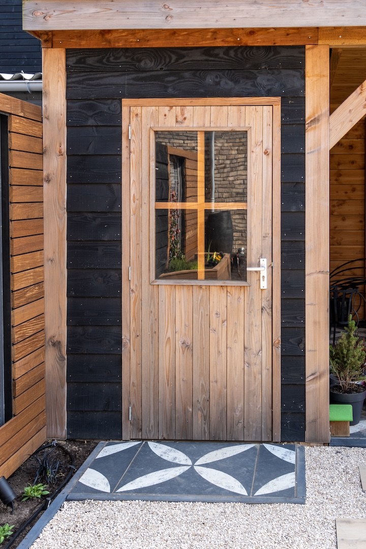 Houten deur in een houten schuur bij tuinaanlegproject in Almere door Snijers Tuinen.