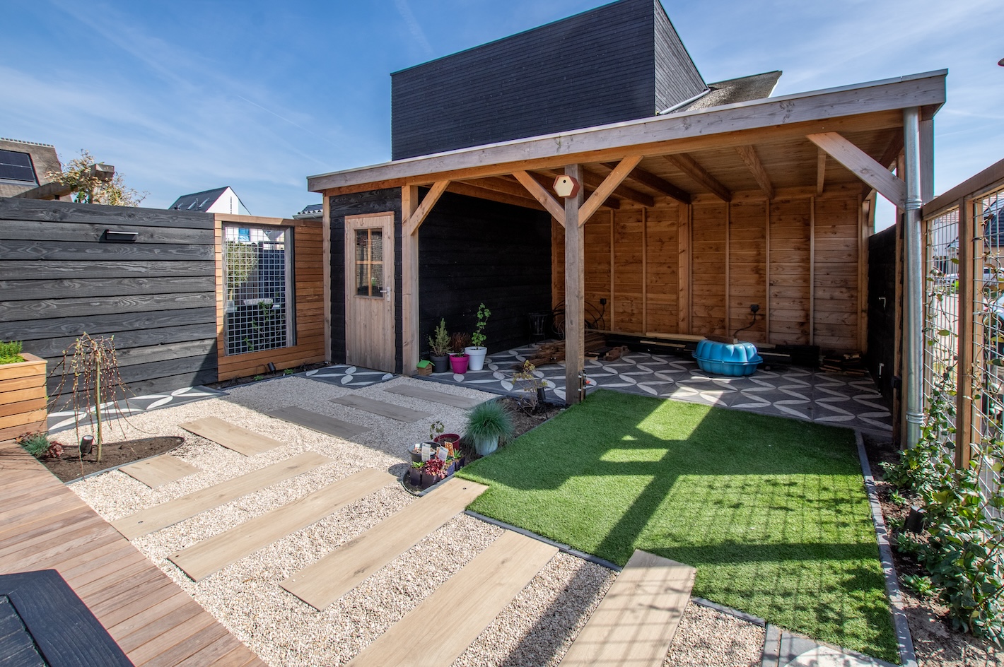 Achtertuin met houten terras, tafel en stoelen bij tuinaanlegproject in Almere door Snijers Tuinen.