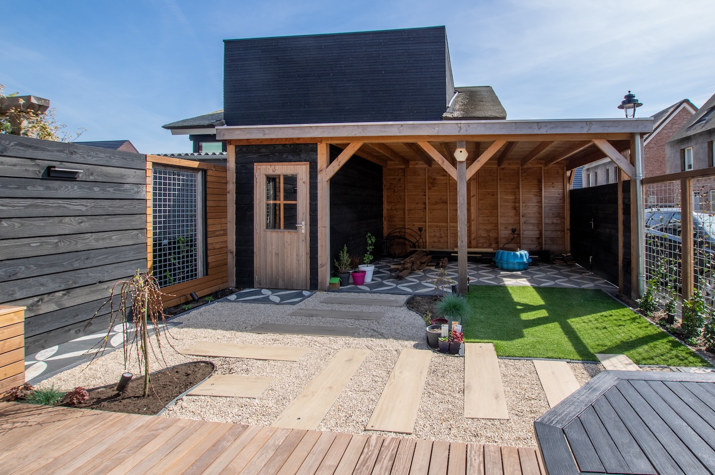 Betegeld pad met houten accenten in de tuin bij tuinaanleg project in Almere door Snijers Tuinen.