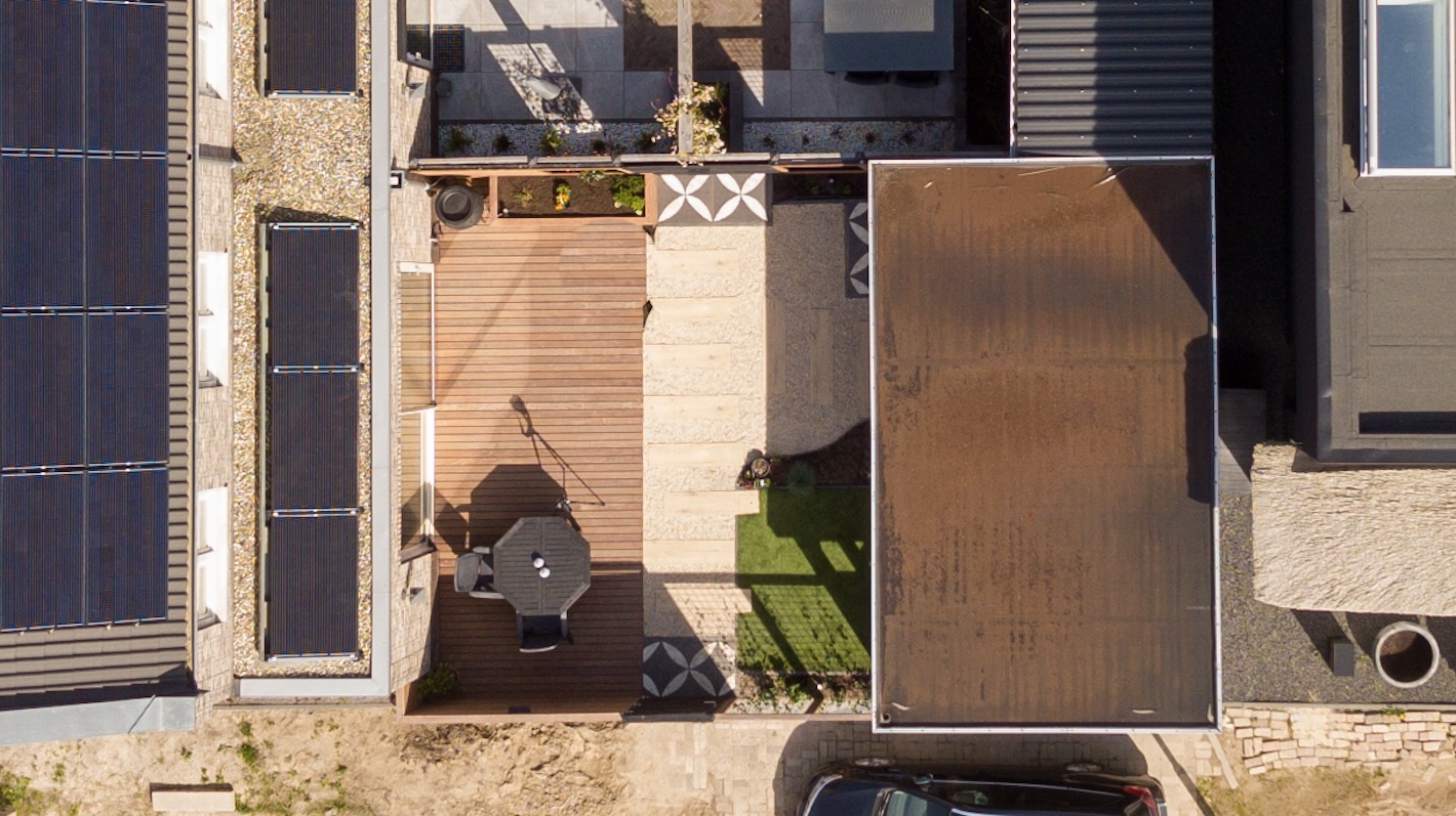 Luchtfoto van achtertuinen met verschillende terrassen en kunstgras, onderdeel van tuinaanlegproject in Almere door Snijers Tuinen.