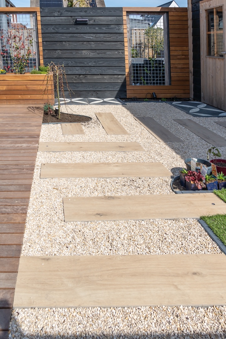 Betegeld pad met houten accenten in de tuin bij tuinaanlegproject in Almere door Snijers Tuinen.